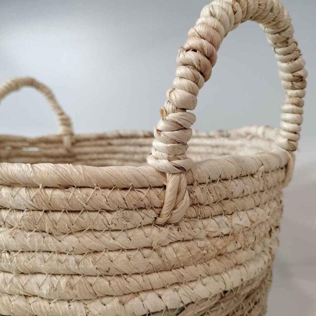 detalle asa cesta de fibras naturales sobre fondo neutro