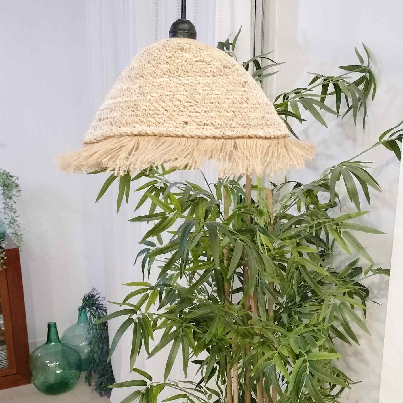 lámpara de esparto sobre planta alta de interior en un salón del catálogo Oxiiro