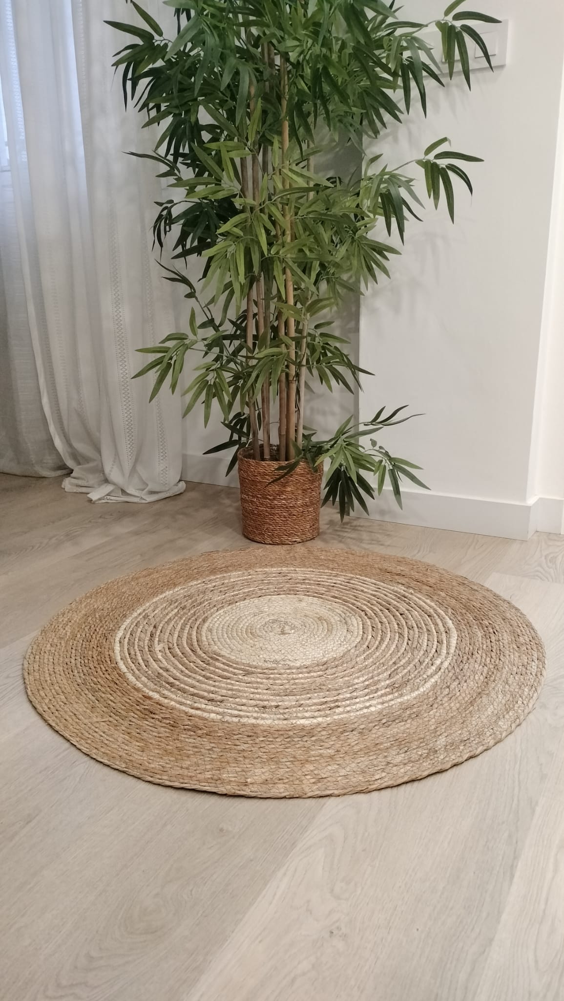 Alfombra rafia fibra natural con maceta de bambú detrás